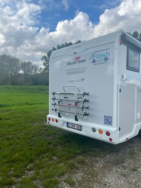 Achteraanzicht van de camper met logo